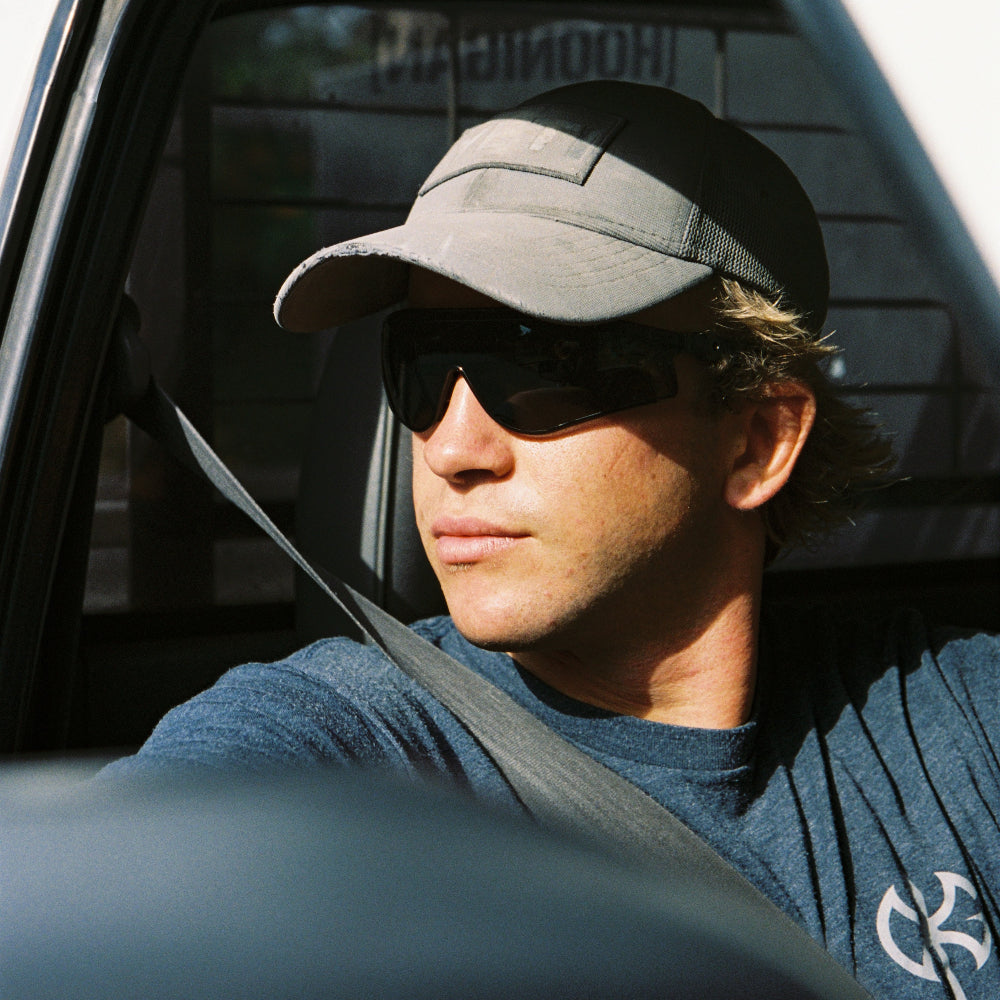Person wearing a Ugly Fish Safety shields looking into a car mirror