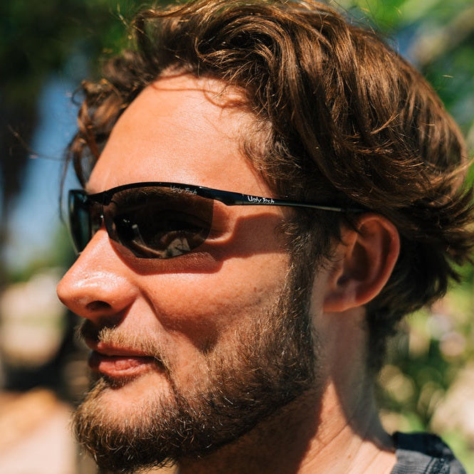 Man wearing Ugly Fish metal sunglasses with a blurred natural background