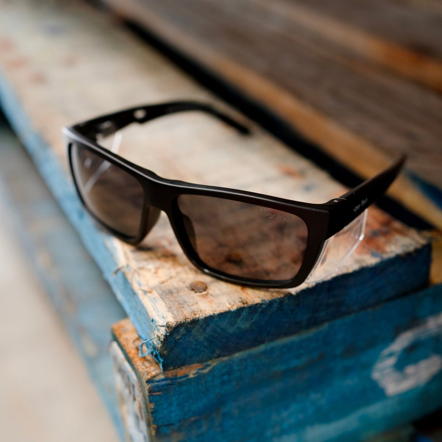 A pair of Ugly Fish Comet Safety Sunglasses sits in a worksite.