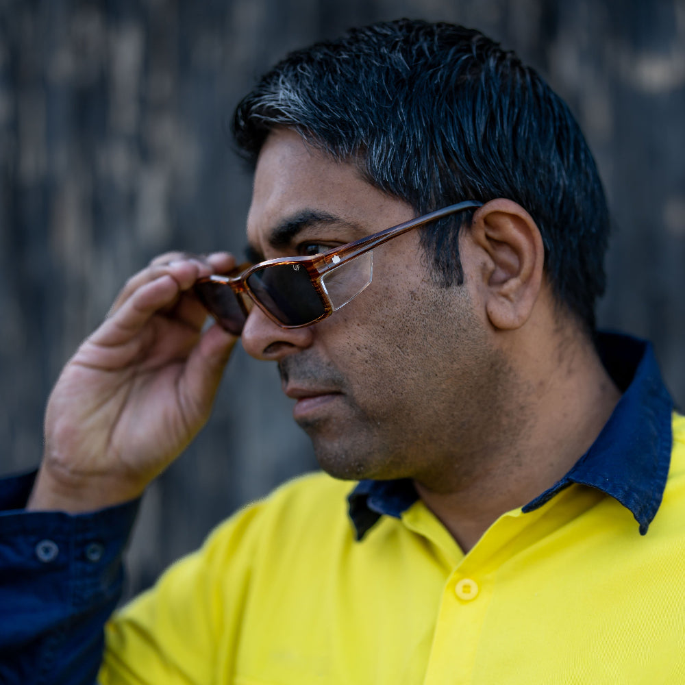Man wearing Ugly Fish Safety sunglasses with a blurred background.