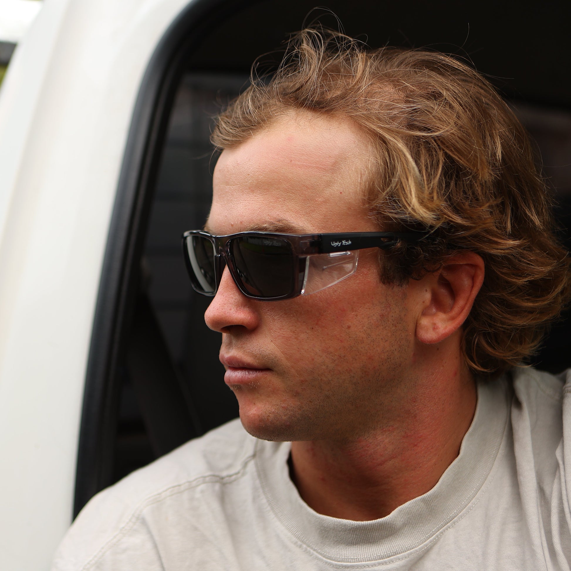 Man wearing safety sunglasses sitting inside a vehicle