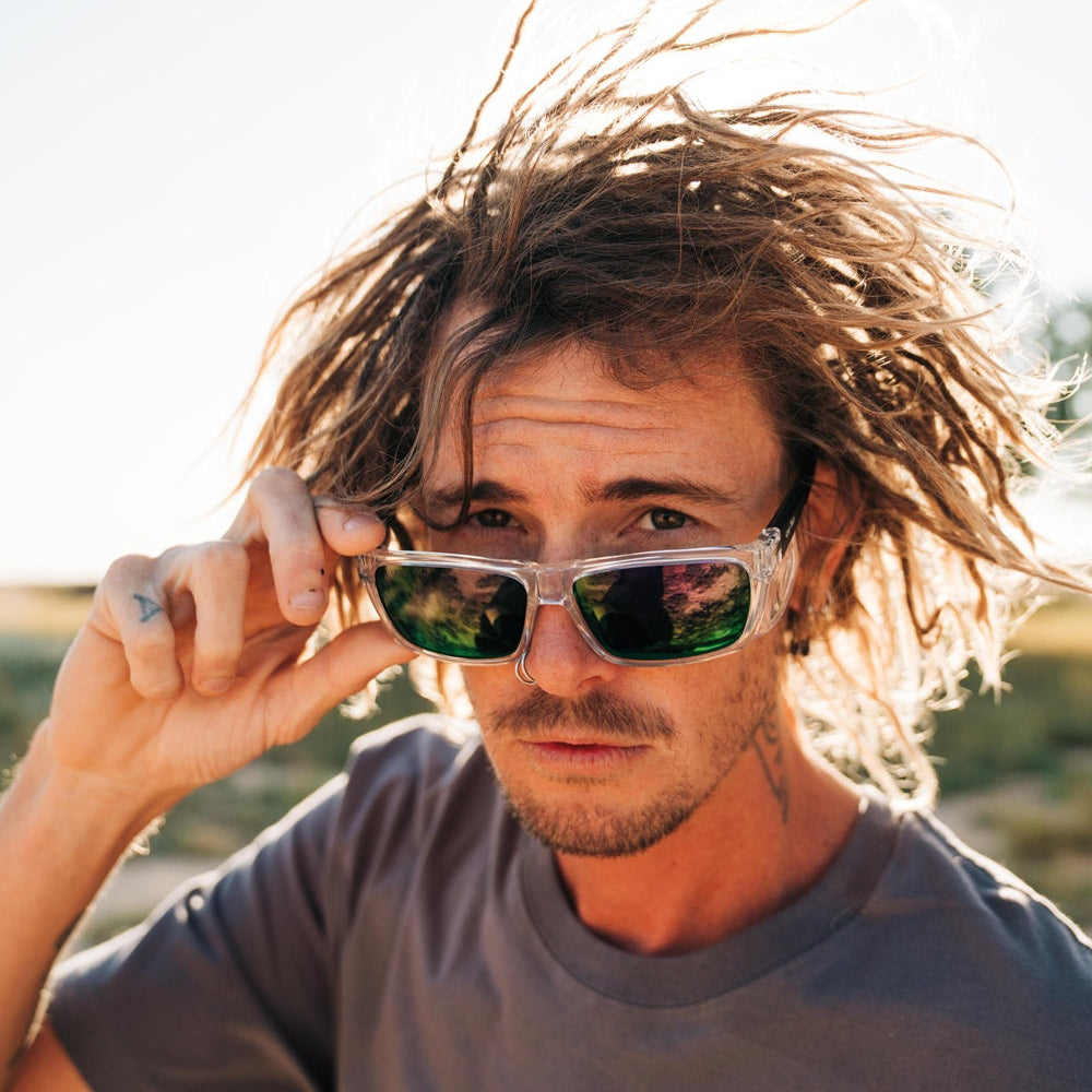 Man with Ugly Fish Certified Safety sunglasses and tousled hair outdoors. 