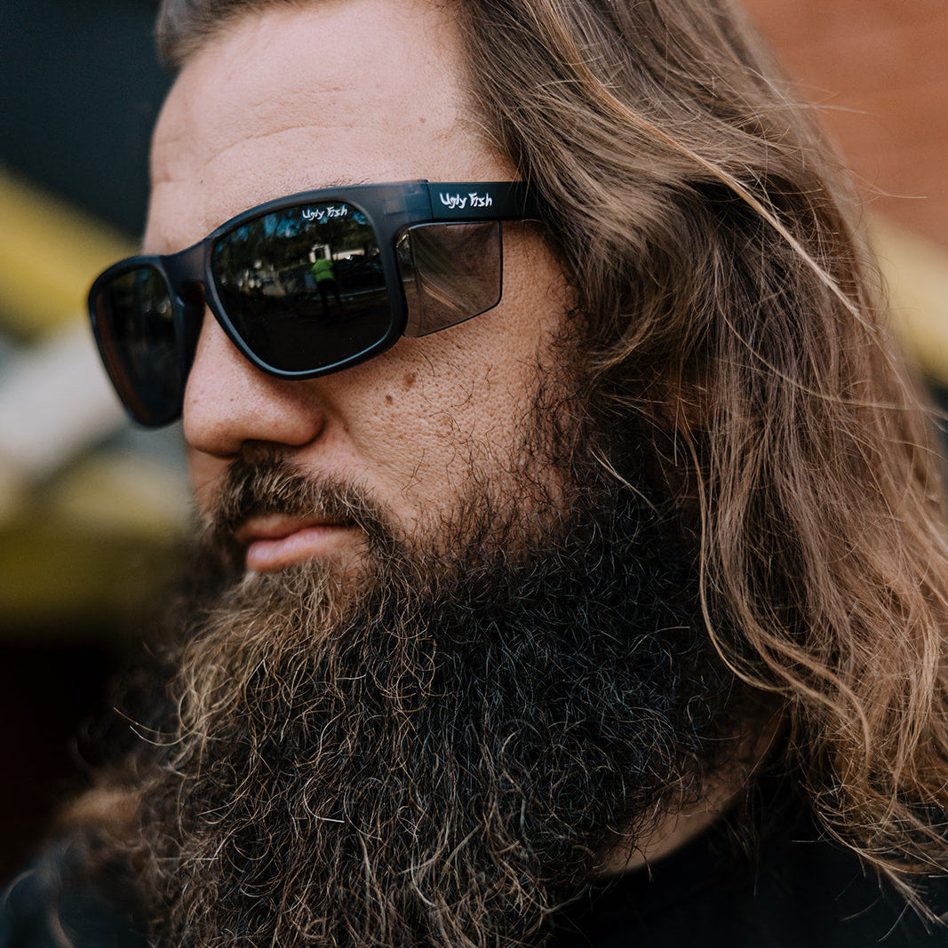 Man with a beard and Ugly Fish Freestone safety sunglasses wearing a black shirt