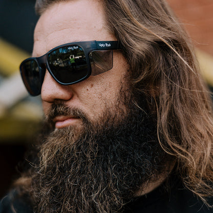 Man with a beard and Ugly Fish Freestone safety sunglasses wearing a black shirt