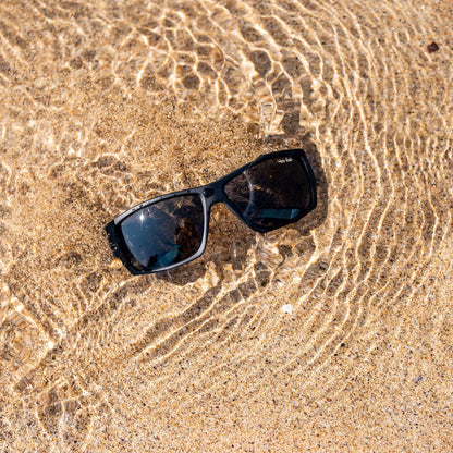 Ugly Fish floating sunglasses on wet sand with water droplets